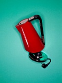 Close-up of red kettle on turquoise background