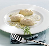 Northern pike dumplings with dill sauce on plate