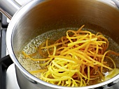 Close-up of carrot slices being added in orange sauce, step 2