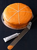 Close-up of orange cake with sugar writing
