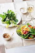 Two summer salads: wild herb salad, and a mixed leaf salad with fruits