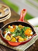 Dandelion leaves with fried potatoes in pan