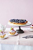 A blueberry tart with mascarpone and mini berry tartlets