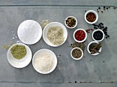 Various salt and pepper in small bowls