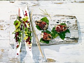 Quails on double skewers with red currant salad