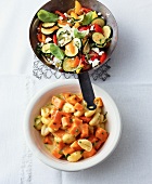 Stir fry vegetable with feta cheese in pan and pumpkin gnocchi ragout in bowl