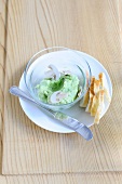 Avocado dip in bowl with bread slices on plate