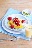 Fruit salad with lemon foam on plate