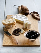 Raw milk cheese with black nuts on chopping board