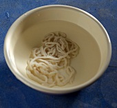 Close-up of sausage casings in bowl of cold water