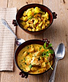 Two pots with chicken curry and chicken