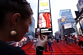 Woman photographing her friend at Times Square in New York, USA