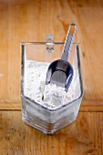 Flour in glass container on wooden surface