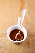 Brown sauce with spoon in bowl
