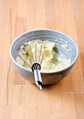 Freshly prepared mayonnaise in bowl with whisk