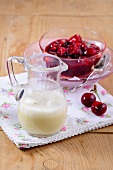 Red fruit jelly in bowl with vanilla sauce in jug