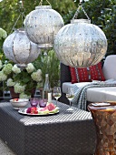 Hanging silver ball lamps with food and beverages on table in Arabian style