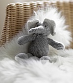 Close-up of knitted soft toy elephant on fur background