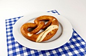 Plate with pretzel on blue checked napkin