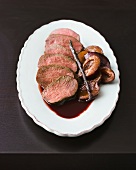 Venison loin with plums on plate