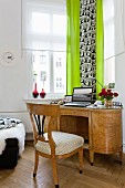 Writing desk and wooden chair in front of window with citrus green curtains