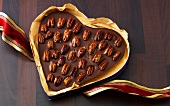 Close-up of chocolate walnut heart in can on wooden surface