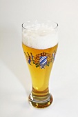 Tall glass of bear with foam on white background