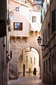 Woman walking in alley at the old town of Palma, Spain