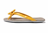 Close-up of yellow sandal made of nappa leather with decorative bow