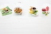 Four different type of desserts with fruit on white background