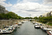 Boats moored in small harbour channel in Paris, France
