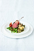 Rack of lamb with vegetables and olive pesto on plate