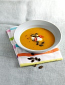 Pumpkin and yoghurt soup in bowl on napkin