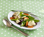 Colourful spring vegetables in serving dish