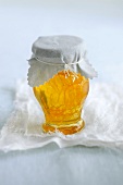 Orange peel and honey in jar tied up with cloth