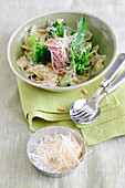 Farfalle with broccoli, rockets, ham and pine nuts