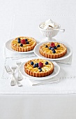 Apple tarts with almond cream, mascarpone and berries on plates