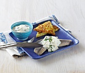 Herring with hash browns and yogurt sauce on plate