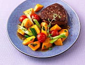 Roasted steak with cherry tomatoes and pumpkins on plate