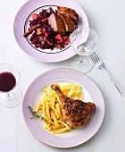 Goose breast with red cabbage and duck legs on plates