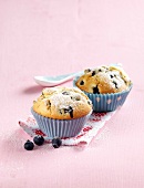 Blueberry muffins on napkin on pink background