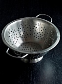 Colander on black background