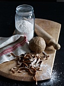 Dough ball, flour, rolling pin and pasta on wooden board