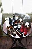 Variety of shoes on table with brush and animal figure