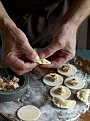 Close-up of meat stuffed in dough for preparation of tortellini pasta, step 2