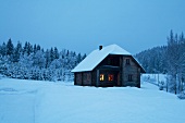 View of wooden holiday house in snowy mountains at night