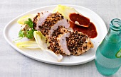 Boneless chicken with pepper crust and sauce on plate