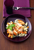 Marinated chicken breast garnished with diced vegetables and herb on plate