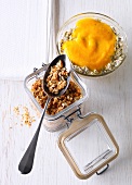 Porridge with poppy seeds in bowl and jar of crunchies 