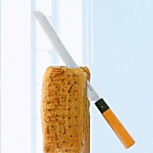 Brotmesser "Chroma Haiku Damascus" steckt in einem Brotlaib